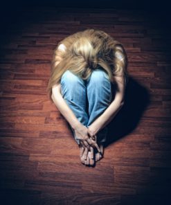 Sad woman sitting alone in a empty room